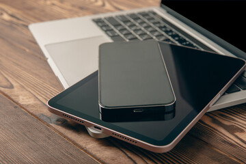 Open laptop with digital tablet and smartphone on the office table. Office workplace with text space. top view, flatley. MOCAP. Technology concept.