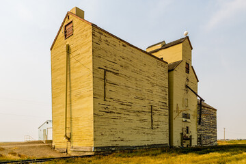 Fototapeta na wymiar Old white wooden grain elevator by the tracks. Skiff, Alberta, Canada
