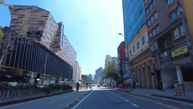 Time lapse in the seventh avenue of Bogota, Colombia in the bike path during the Ciclovia day. Big buildings, cyclists, cars and blue sunny sky