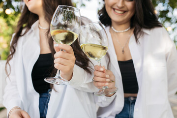 Girls in the garden. Girls drink wine at a beautiful garden.
