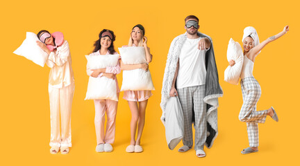 Beautiful young women in pajamas and with pillows on color background