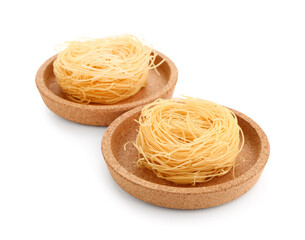 Plates of raw pasta nests on white background