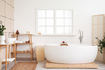 Naklejka na ściany i meble Interior of bathroom with modern bathtub, ceramic sink and laptop on board