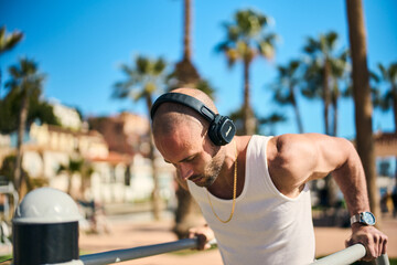 young guy exercising with calisthenics workout in an outdoor gym