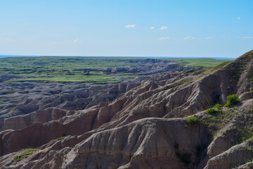 panorama of the mountains exposed rock geology with blue sky and green grass plateaus badlands