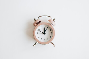 Pink alarm clock on a white background