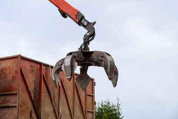 Loading scrap metal into a truck Crane grabber loading metal rusty scrap in the dock A grapple...