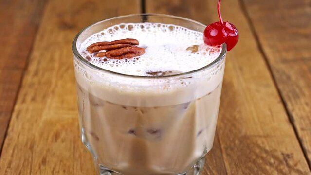 Closeup of kahlua drink with coffee, alcohol and milk on a wooden table.