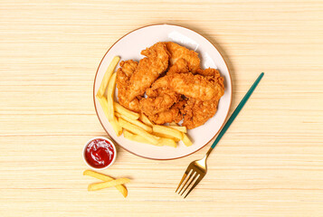Plate with tasty nuggets, french fries and sauce on wooden background