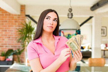 pretty young woman with dollarbanknotes at home interior