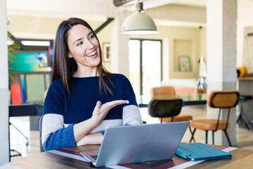 young pretty woman smiling cheerfully, feeling happy and showing a concept. telecommuting concept