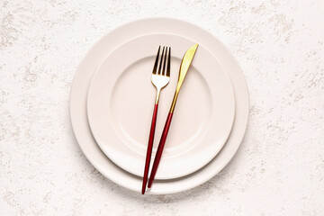 Plates with fork and knife on white grunge background