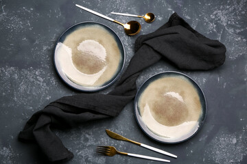Plates and set of cutlery on grey grunge background