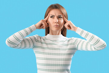 Thinking young woman on blue background