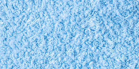 Green fuzzy and fluffy towel fabric close up. Fleece cozy shower towel background with space for text