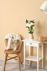 Interior of living room with flowers and plant branches in vases on table