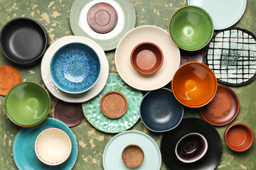 Composition with clean ceramic plates and bowls on green grunge background