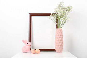 Obraz premium Blank frame, vase with gypsophila flowers, Easter eggs and bunny on white background