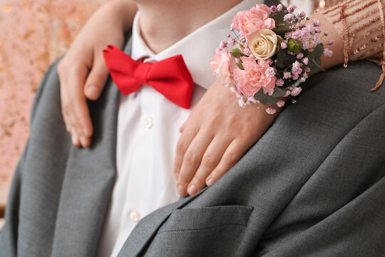 Young woman with corsage hugging her prom date, closeup