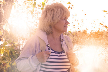 Day dreaming senior  woman outdoors. confident senior woman looking thoughtful during  walking countryside. Travel, vacations