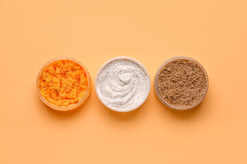 Jars of natural body scrub on color background