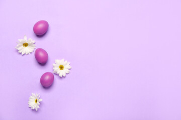 Composition with painted Easter eggs and chamomile flowers on lilac background