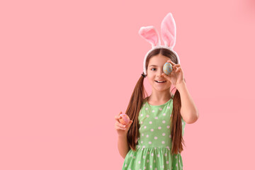Cute little girl in bunny ears on pink background