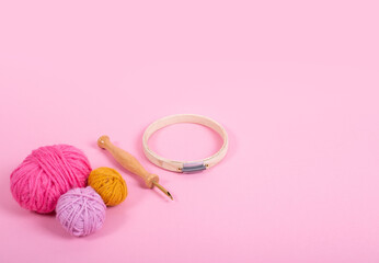 Material para bordar, aguja mágica, bastidor, madejas de lana, sobre fondo rosa para crear cursos...