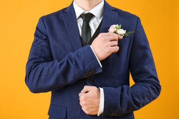 Young guy in prom suit and with boutonniere on yellow background © Pixel-Shot