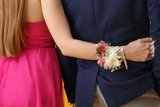 Young girl with corsage hugging her prom date, back view