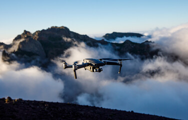 Drone with camera flying over the mountains.