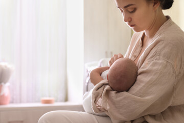 Obraz na płótnie Canvas Mother holding her sleeping baby at home, closeup