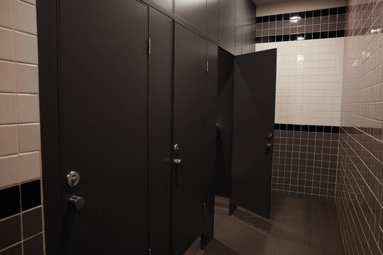 Public toilet interior with stalls and tiled walls