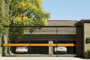 Fototapeta premium Security metal gates near trees and estate outdoors