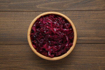 Tasty red cabbage sauerkraut on wooden table, top view