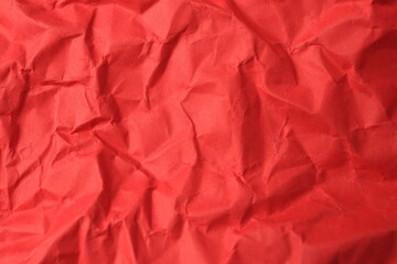 Sheet of crumpled red paper as background, top view