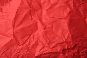 Sheet of crumpled red paper as background, top view