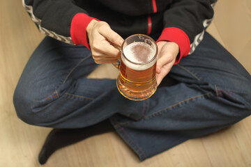 a person holds a full mug of beer