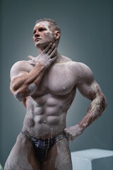 Fototapeta na wymiar Muscular man touching himself, male posing in studio