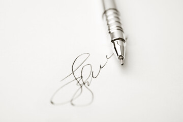 Modern pen and signature on sheet of white paper, closeup