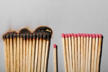 Burnt and whole matches on light grey background, flat lay
