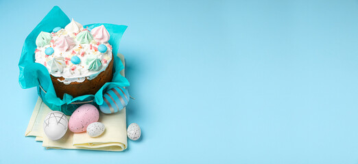 Traditional Easter cake with meringues and painted eggs on light blue background, space for text. Banner design