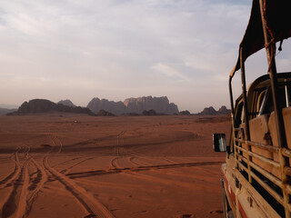 Wadi Rum Desert rock structures with Jeep in the foreground. 