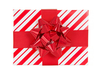 top view close up of one red and white striped present box tied with red fabric ribbon topped with shiny red bow. Isolated on white.