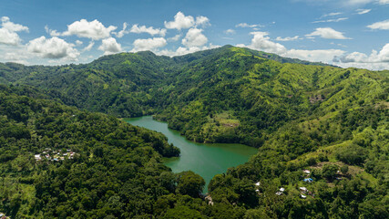 Fototapeta na wymiar A beautiful lake among the mountains with tropical vegetation. Lake Balanan. Negros, Philippines