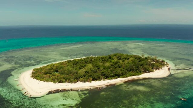 Small tropical island on an atoll with beautiful sandy beach surrounded by coral reef from above. Tropical island and coral reef. Summer and travel vacation concept, Camiguin, Philippines, Mindanao