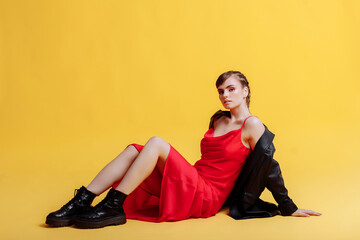 Portrait of a beautiful woman model in a red dress with braids and bright makeup. Model portrait of...