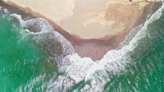 Aerial top down shot of waves reaching the shore at Tortuga Island, Costa Rica.