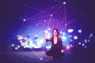 Happy businesswoman sitting on futuristic background touching network on screen