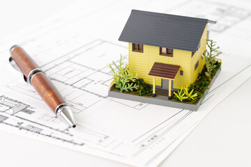 不動産の打ち合わせと設計図。植物や植栽のある家の模型